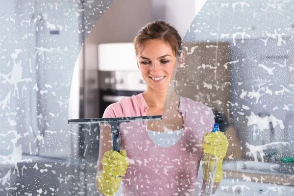 Žena čistí okno — Stock fotografie