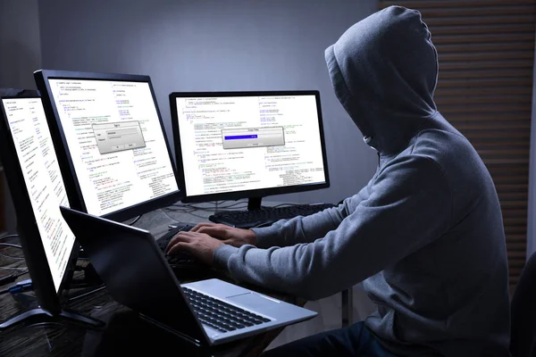 Хакер за допомогою декількох комп'ютерів — стокове фото