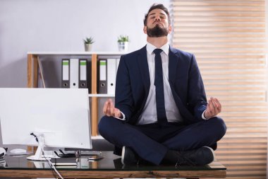 Ofiste meditasyon yapıyor işadamı