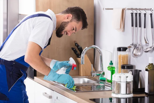 Мужчина чистит столешницу кухни — стоковое фото