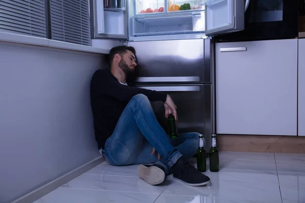 Hombre sentado en el piso bebiendo cerveza — Foto de Stock