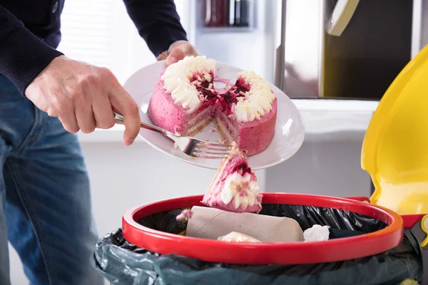 Person wirft Kuchen in Müll — Stockfoto