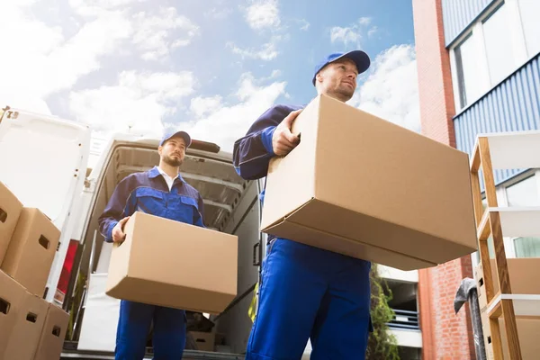 Homens de entrega transportando caixas de papelão — Fotografia de Stock