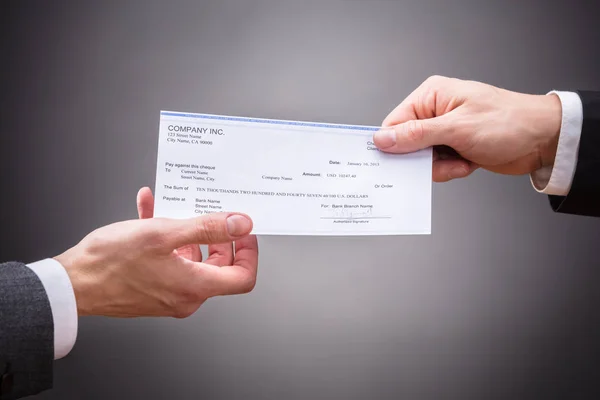 Empresário que dá o cheque — Fotografia de Stock