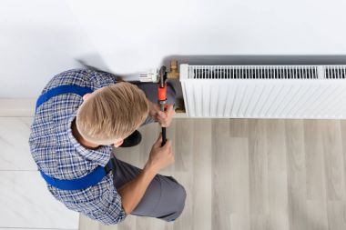 Erkek tesisatçı anahtarı evde kullanarak termostat sabitleme Close-Up