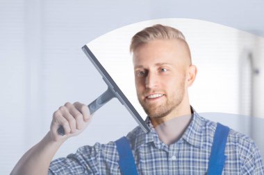 Genç bir işçi cam çekçek mutfak ile temizlik gülümseyen 