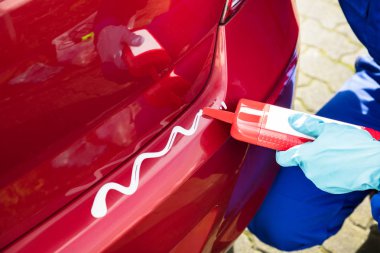 Birinin elini şişe temiz karışımla araba üzerinde uygulama eldivenler