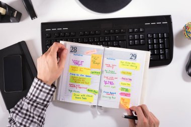 Yükseltilmiş görünümü işadamı el sopa not bilgisayar klavye üstünde okul sırası ile günlüğünden kaldırma