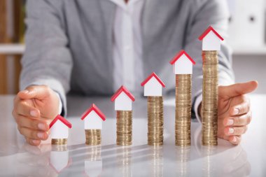 Ev modelleri tablo üzerinde yığılmış sikkeler üzerinde koruma işadamının midsection
