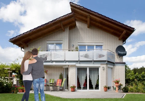 Bakifrån Ett Ungt Par Som Pekar Nya Huset — Stockfoto