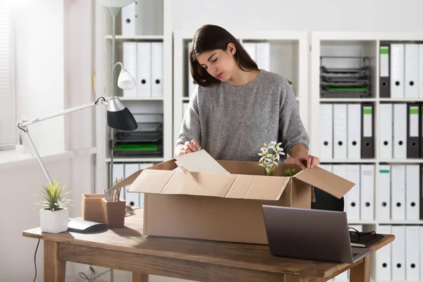 Triste Joven Empresaria Empacando Sus Pertenencias Caja Cartón Lugar Trabajo —  Fotos de Stock