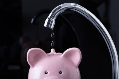 Siyah arka plan üzerinde servet içinde musluk damlayan su
