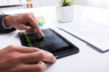 Office dijital tablet grafik analiz bir işadamının'ın el Close-Up
