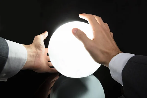 輝く水晶玉で未来を予測する実業家の手のクローズ アップ — ストック写真