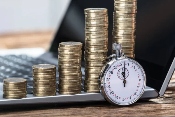 Primer Plano Cronómetro Con Aumento Monedas Apiladas Ordenador Portátil —  Fotos de Stock