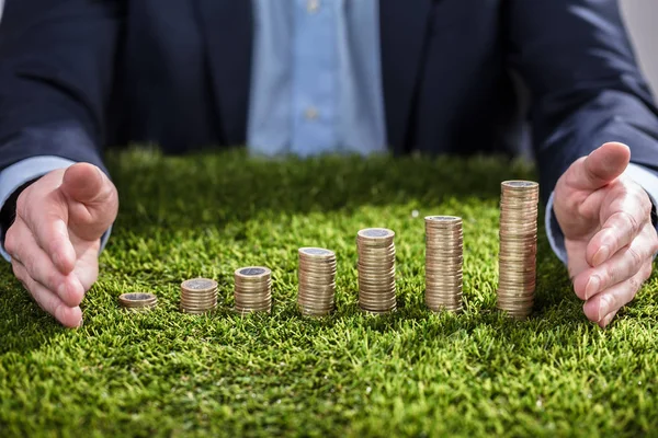 Close Van Een Zakenman Hand Beschermen Gestapelde Munten Groen Gras — Stockfoto