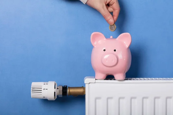 Van Iemands Hand Munt Invoegen Piggy Bank Radiator — Stockfoto