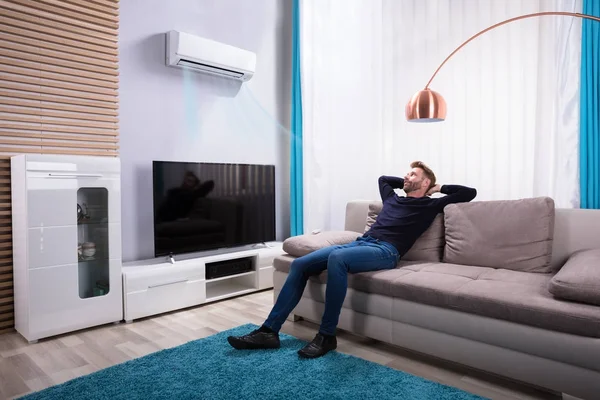 Junger Mann Entspannt Auf Sofa Der Nähe Des Fernsehers Hause — Stockfoto