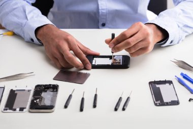 Bir teknisyen el masa üzerinde cep telefonu tamir Close-Up