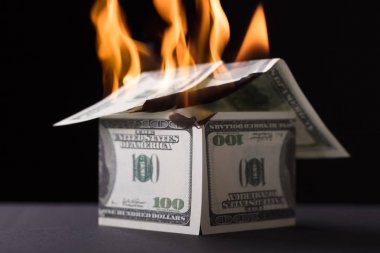 Siyah arka plan karşı yangında yanan banknot oluşan ev