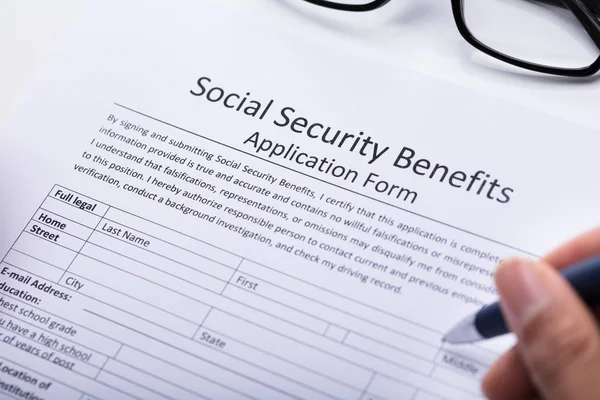 Bliska Osoba Ręka Napełniania Zabezpieczenia Społecznego Świadczenia Formularz Wniosku — Zdjęcie stockowe