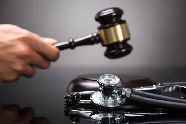 Mão Juiz Golpeando Gavel Com Estetoscópio Mesa — Fotografia de Stock