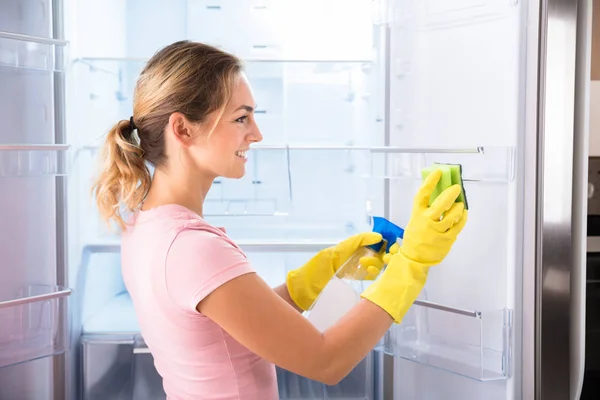 Mujer Joven Que Usa Guantes Que Limpian Refrigerador Con Botella —  Fotos de Stock