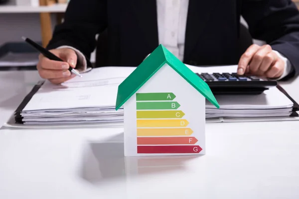 Affärskvinna Beräkning Finansiella Data Med Hus Modell Visar Energi Effektivitetsgrad — Stockfoto