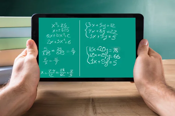机の上画面にデジタル タブレットの数学の方程式を持っている人の手のクローズ アップ — ストック写真
