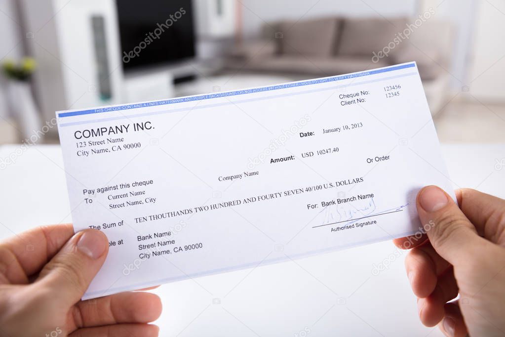 Close-up Of A Person's Hand Holding Cheque