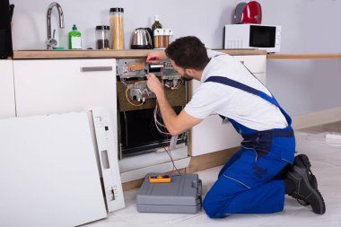Erkek teknisyen bulaşık makinesi incelenmesi ile dijital multimetre