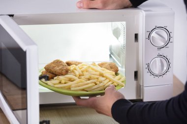 Fried gıda mikrodalga fırın içinde koyarak bir birinin elini Close-Up