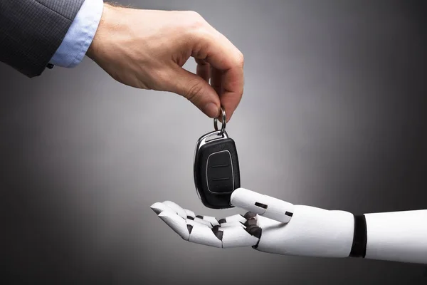 Nahaufnahme Der Hand Eines Geschäftsmannes Der Einem Roboter Den Autoschlüssel — Stockfoto