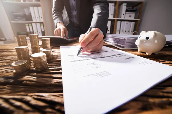 Close Van Een Ondernemer Hand Ondertekening Document Met Gestapelde Gouden — Stockfoto