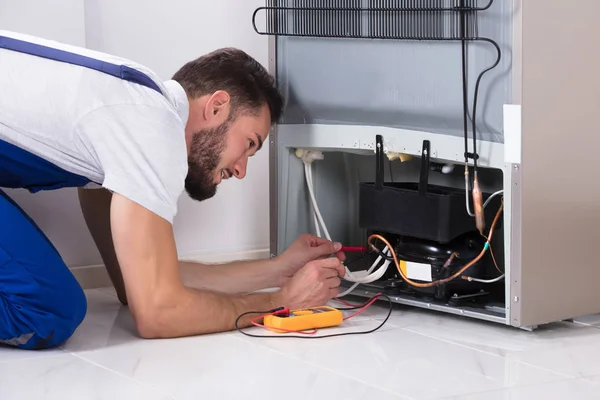 Técnico Masculino Examinando Refrigerador Con Multímetro Digital — Foto de Stock