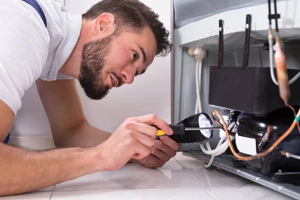 Foto Van Mannelijke Technicus Herstellen Koelkast Met Schroevendraaier — Stockfoto