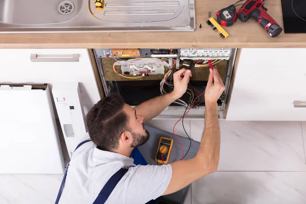 Tecnico Maschio Che Esamina Lavastoviglie Con Multimetro Digitale — Foto Stock