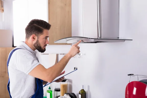 Male Electrician Clipboard Repairing Kitchen Extractor Filter — Stock Photo, Image