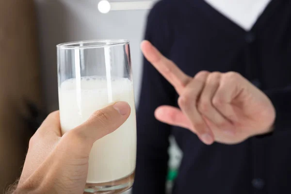 关闭一个人的手拒绝玻璃的人提供的牛奶 — 图库照片