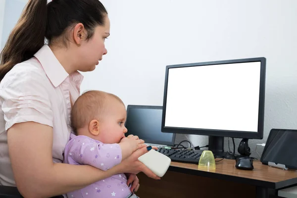 与她的婴孩的妇女使用空白的白色屏幕的计算机 — 图库照片