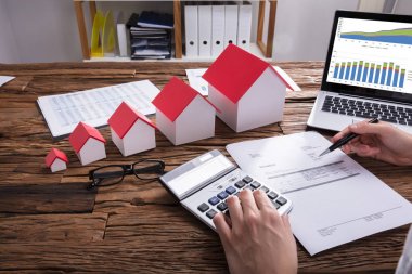 Bill ev modeli ve Laptop üstünde okul sırası ile hesaplama bir işadamının'ın el Close-Up