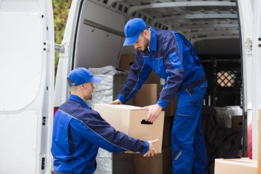 İki genç erkek Movers kamyondan karton kutu taşıma