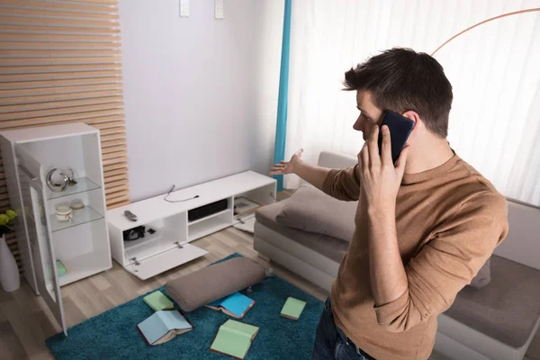 Jovem Preocupado Conversando Telefone Apontando Para Televisão Roubada Casa — Fotografia de Stock