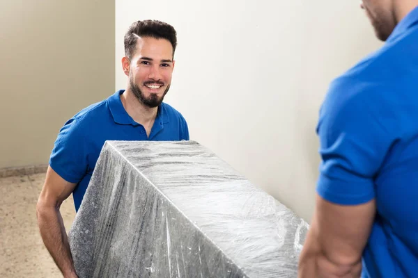 Dvě Mladé Mužské Movers Uniformě Nesoucími Nábytek Schodiště — Stock fotografie