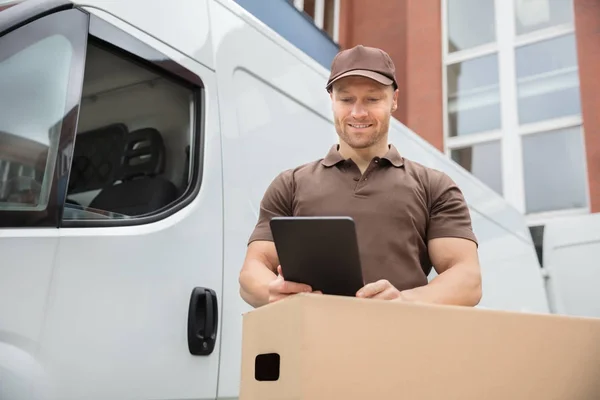 Happy Delivery Man Standing Near Van Using Digital Tablet