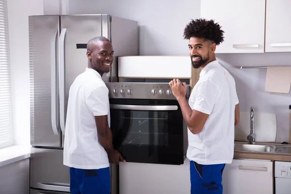 Dois Trabalhadores Sexo Masculino Uniforme Fixando Forno Cozinha Casa — Fotografia de Stock