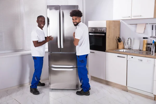 Dois Homens Uniforme Fixando Congelador Cozinha Casa — Fotografia de Stock