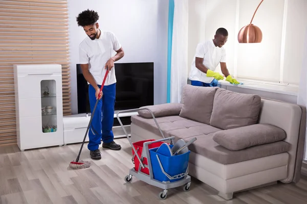 Dois Sorridentes Jovem Zelador Limpando Peitoril Janela Assoalho Mopping Sala — Fotografia de Stock