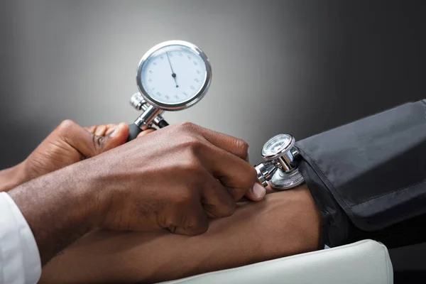 Zbliżenie Mężczyzna Lekarz Pomiaru Ciśnienia Krwi Pacjenta Szarym Tle — Zdjęcie stockowe