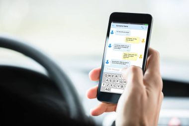 Birinin elini Mobilephone kısa arabanın içine mesaj ile yakın çekim